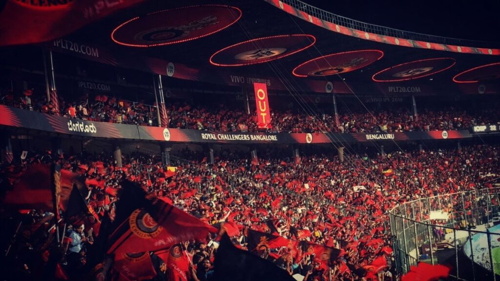 Packed Chinnaswamy stadium crowd creating intense atmosphere as visiting batsman faces pressure during IPL match
